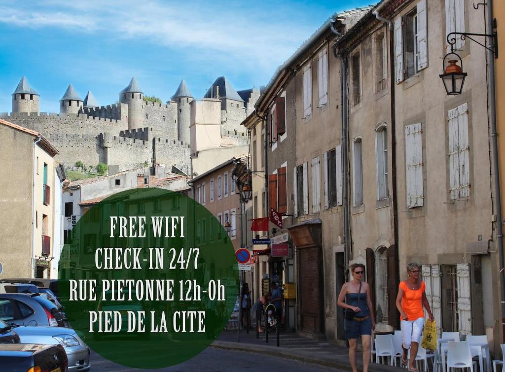 deux femmes marchant dans une rue devant un château dans l'établissement Les Petits Conforts, à Carcassonne