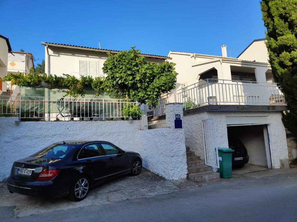 a black car parked in front of a house at Apartmani Nada in Drage