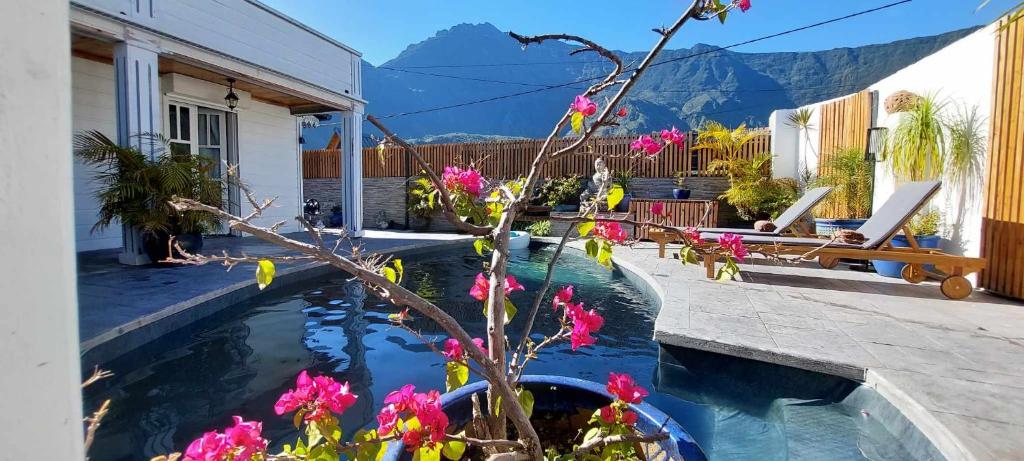 a house with a pool with flowers in the yard at Villa Ananda in Cilaos