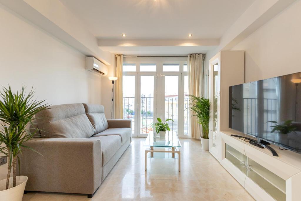a living room with a couch and a tv at Charming 3 Bedroom Apartment at Triana Center By Oui Seville in Seville