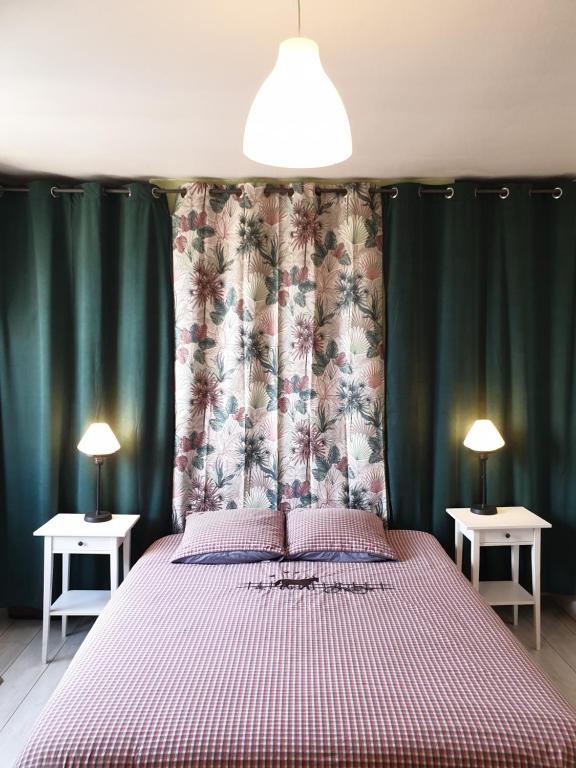 a bedroom with a bed and two tables with lamps at Lam'Bray in Forges-les-Eaux