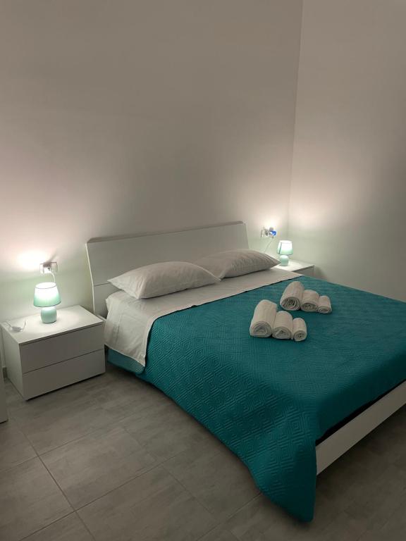 a bedroom with a bed with two slippers on it at Borraco Rooms in San Pietro in Bevagna