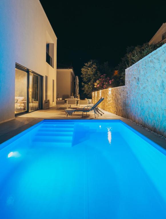 a swimming pool in front of a house at night at Villa Excellente in Mandre