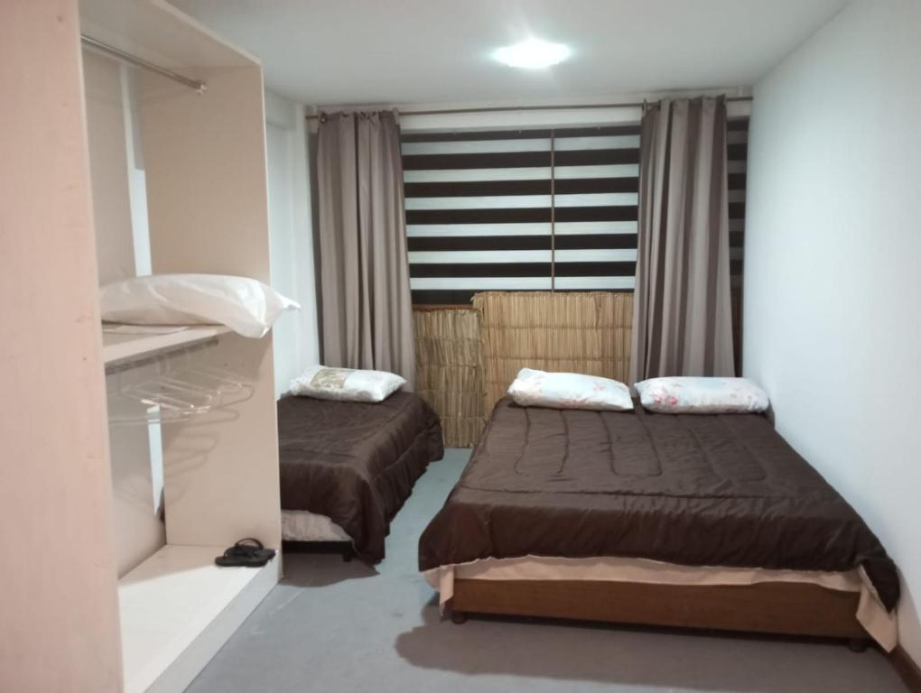 a small bedroom with two beds and a window at APARTAMENTO BARRA DO JUCU VISTA MAR in Vila Velha