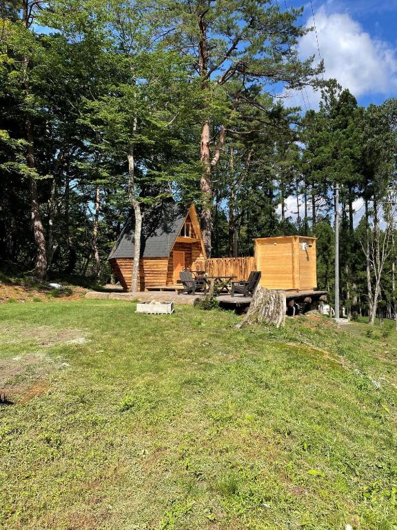 una cabaña de madera en un campo junto a un bosque en North Villge Hirugano - Vacation STAY 17589v, en Gujō