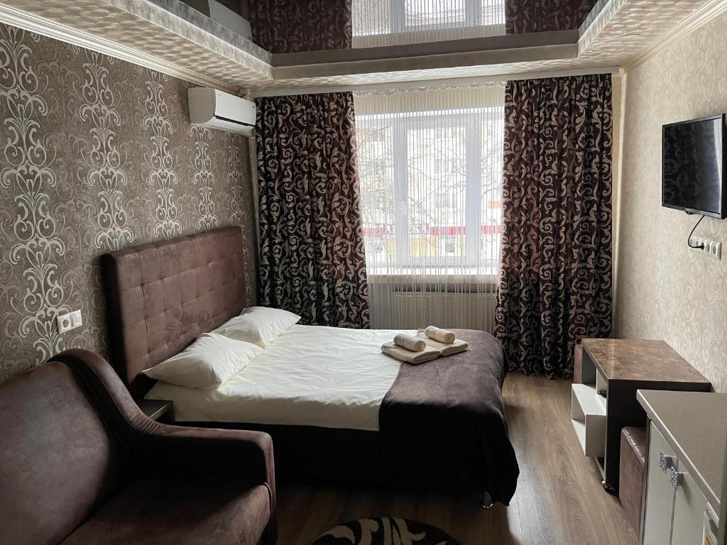 um pequeno quarto com uma cama e uma cadeira em Nirvana em Rivne
