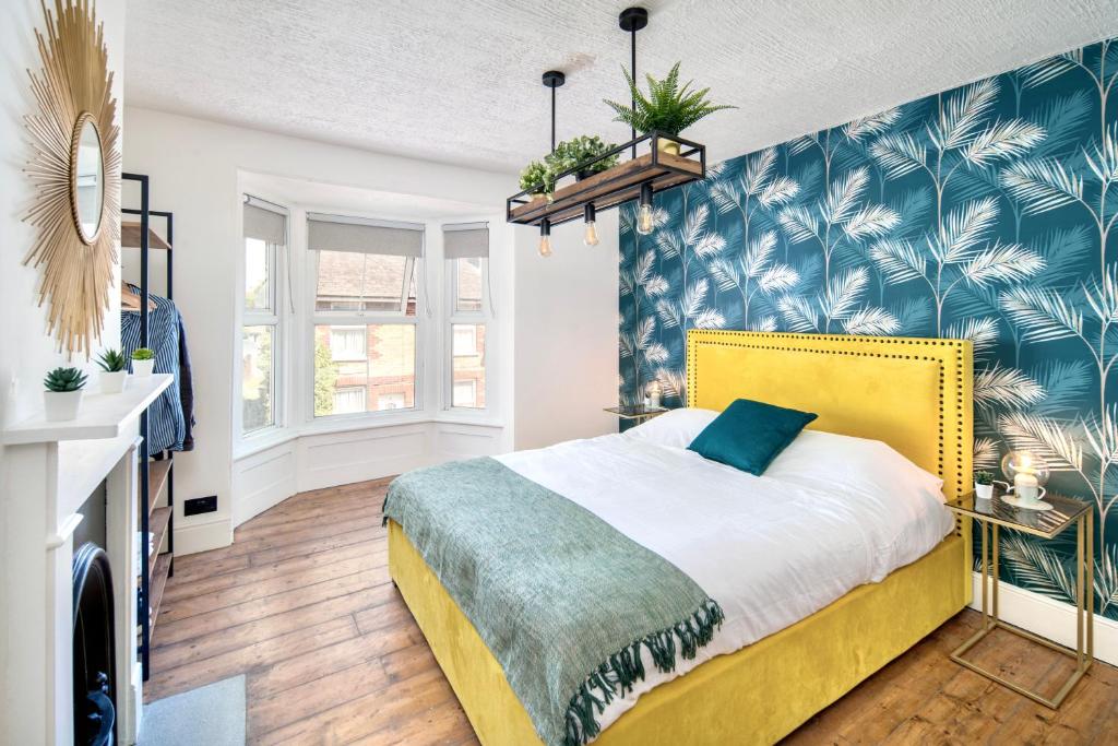 a bedroom with a bed with a yellow headboard at Marina Bridge House Central Cowes in Cowes