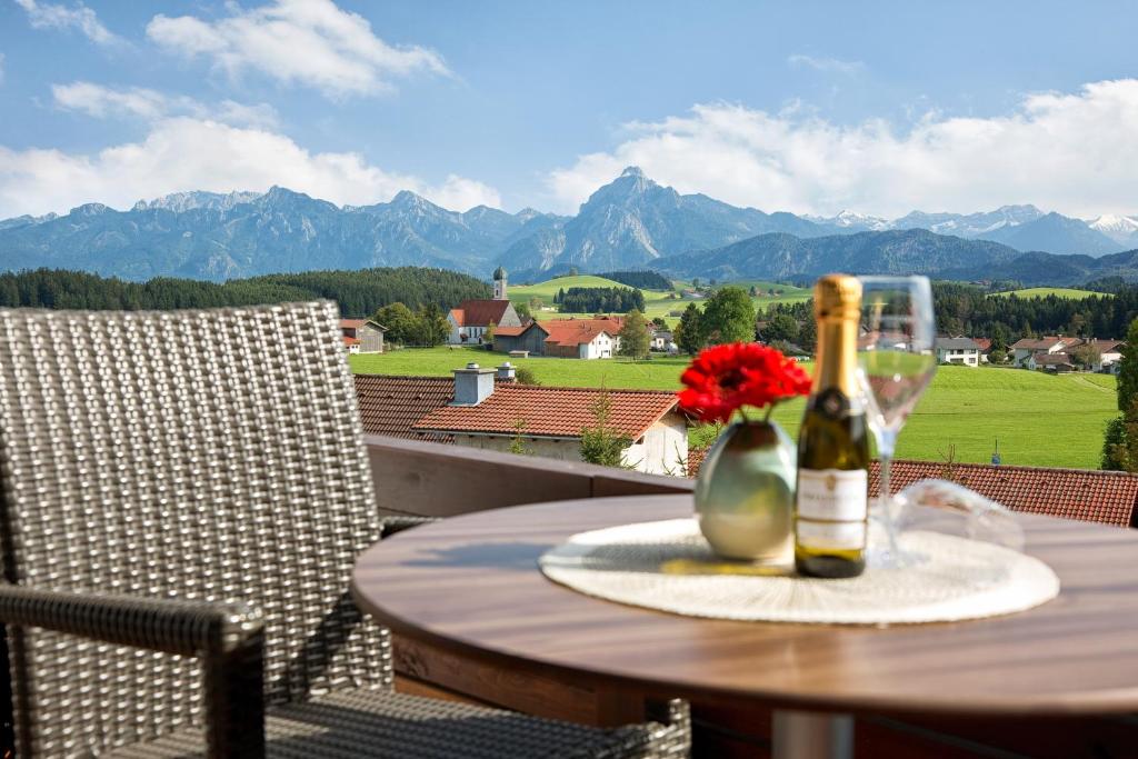 una mesa con una botella de vino y una flor en ella en Landhotel Gockelwirt, en Eisenberg