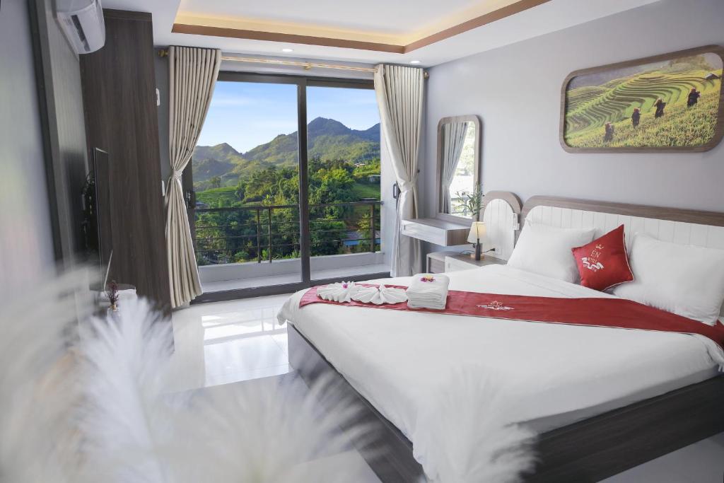 a bedroom with a bed and a large window at En Hotel Sapa in Sa Pa