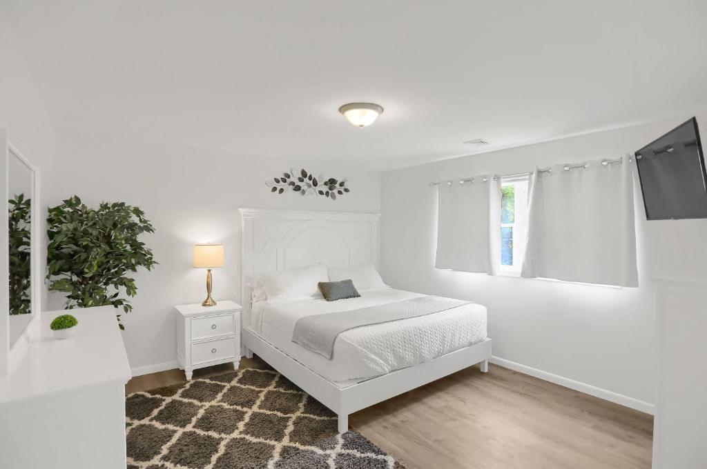 a white bedroom with a white bed and a window at Halifax Inn in Halifax