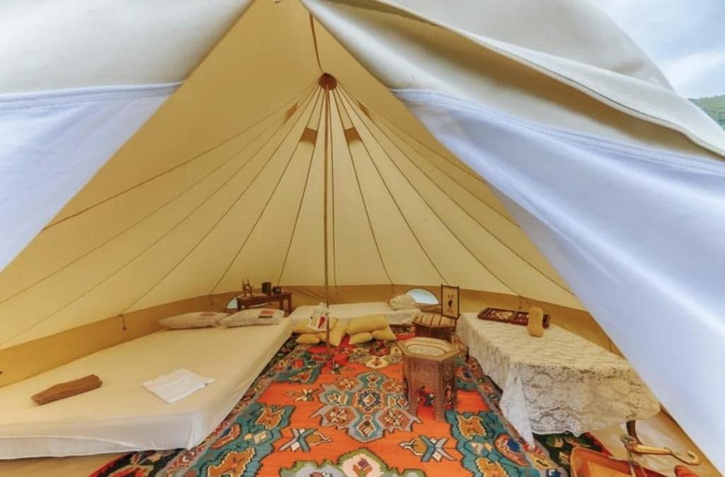 een grote tent met 2 bedden en een tapijt bij White Scale Agroturizmo in Bar