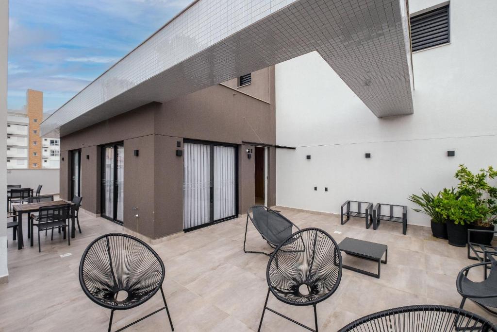 a patio with chairs and tables on a building at Studio para casais bem localizado ARE504 in Florianópolis