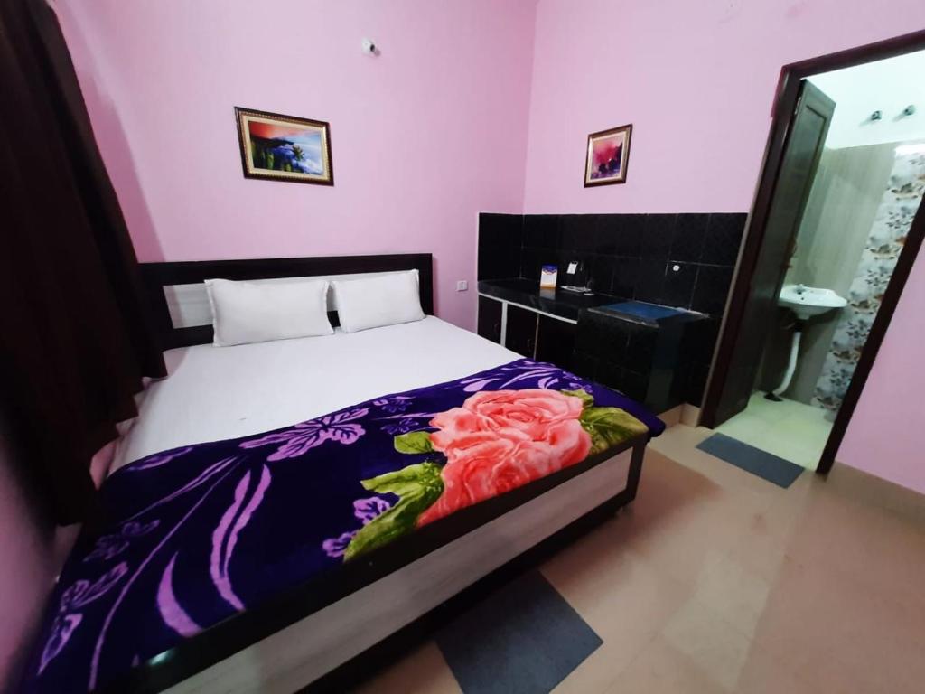 1 dormitorio con 1 cama con pared de color rosa en Goroomgo Jagannath Inn Puri Near Sea Beach, en Puri
