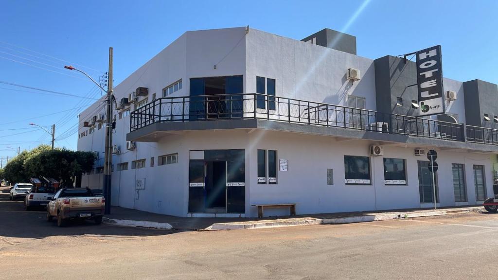 a white building with a balcony on top of it at HOTEL BURITI in Cachoeira Alta