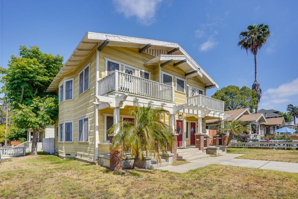 una casa amarilla con una palmera delante de ella en Long Beach Vacation Rental Near Downtown and Beaches, en Long Beach