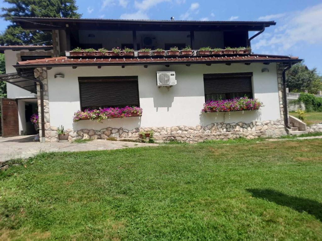 uma casa com duas janelas com caixas de flores em Apartman Slapovi em Krupa na Vrbasu
