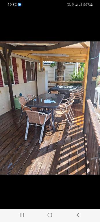 a patio with tables and chairs on a deck at Mobile home dans camping frejus in Fréjus