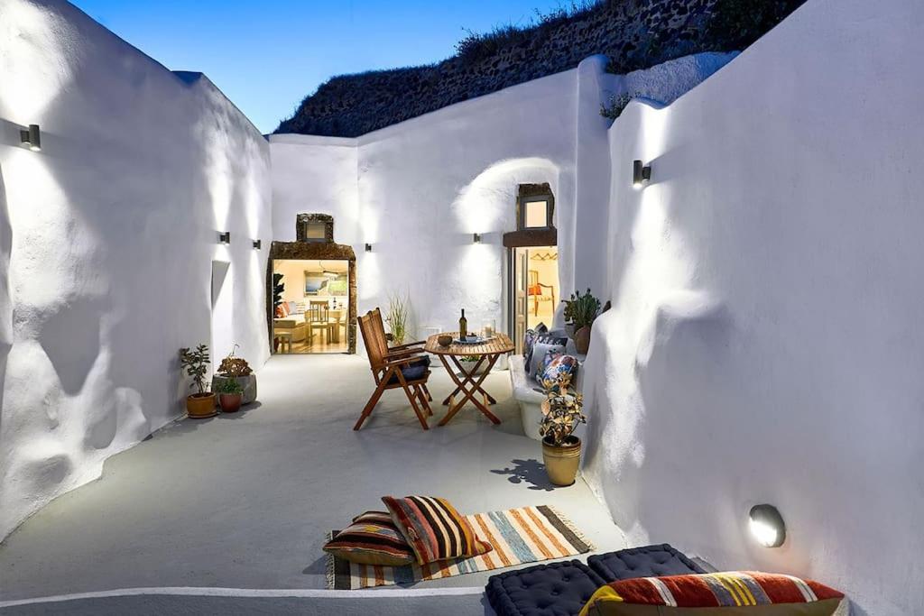 梅加洛寇里的住宿－Villa Agalitsa Cave Houses with Garden Courtyard，白色建筑中带桌椅的庭院