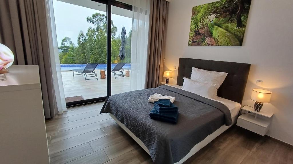 una camera con letto e vista sulla piscina di Casa da Arvore ad Arco da Calheta