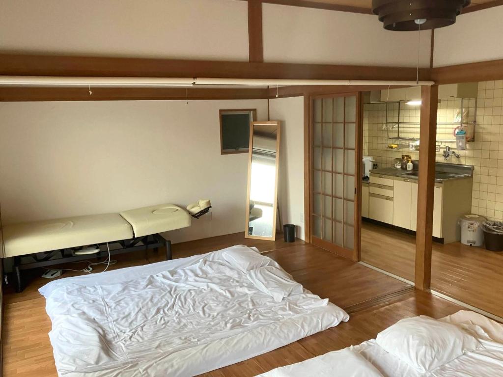 um quarto com duas camas num quarto com uma cozinha em Nishimoto Building - Vacation STAY 93789v em Hiroshima