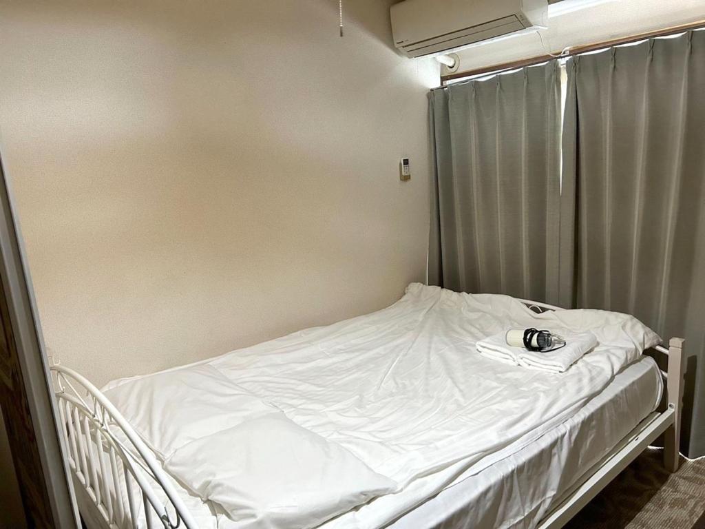 a hospital bed in a room with white sheets at Nishimoto Building - Vacation STAY 16010v in Hiroshima