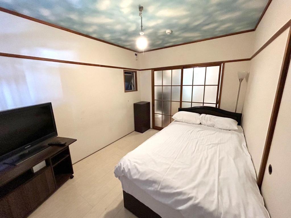 um quarto com uma cama e uma televisão de ecrã plano em Nishimoto Building - Vacation STAY 16015v em Hiroshima