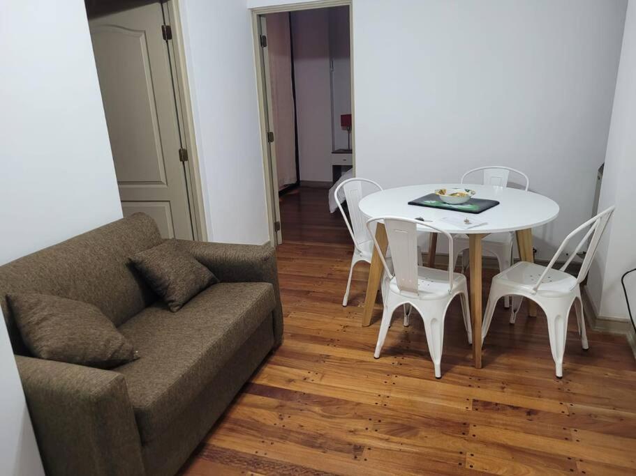 sala de estar con sofá, mesa y sillas en Departamento Plaza España con cochera en Mendoza