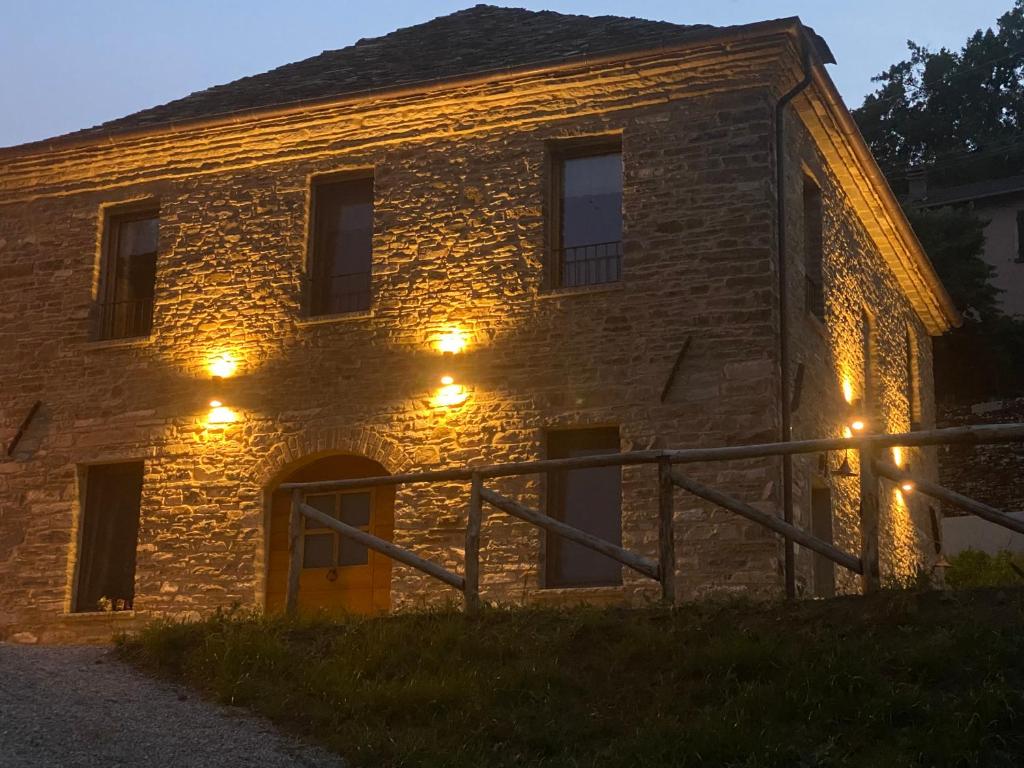 um edifício de pedra com luzes acesas à noite em Agriturismo Il Mulino della Rocca em Berceto