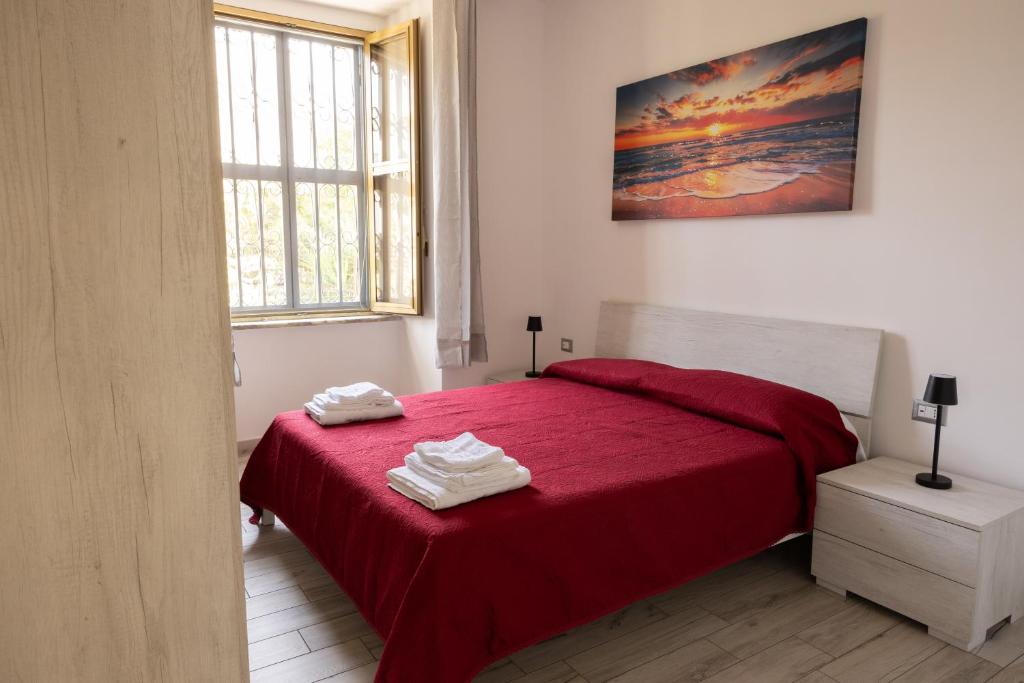 a bedroom with a red bed with towels on it at Domus Re Ferdinando - AIRPORT in Naples