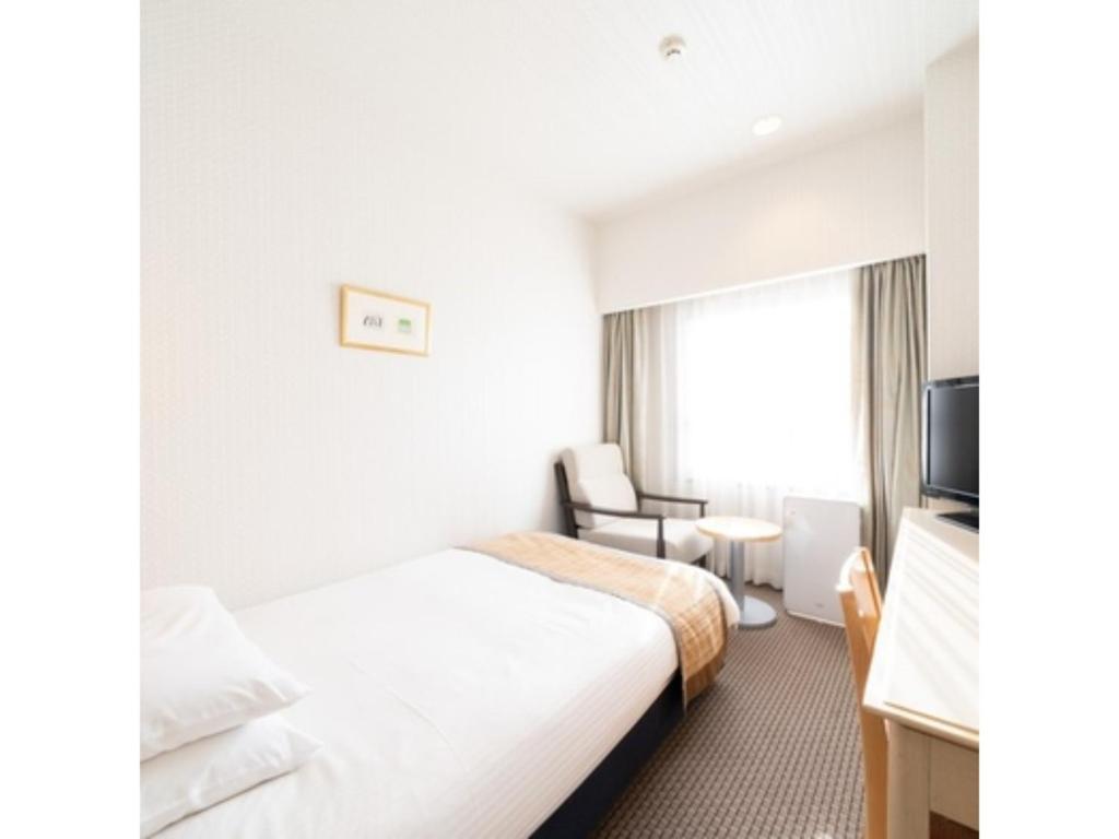 ein Hotelzimmer mit einem Bett und einem Stuhl in der Unterkunft Hotel Terrace The Square Hitachi - Vacation STAY 17018v in Hitachi