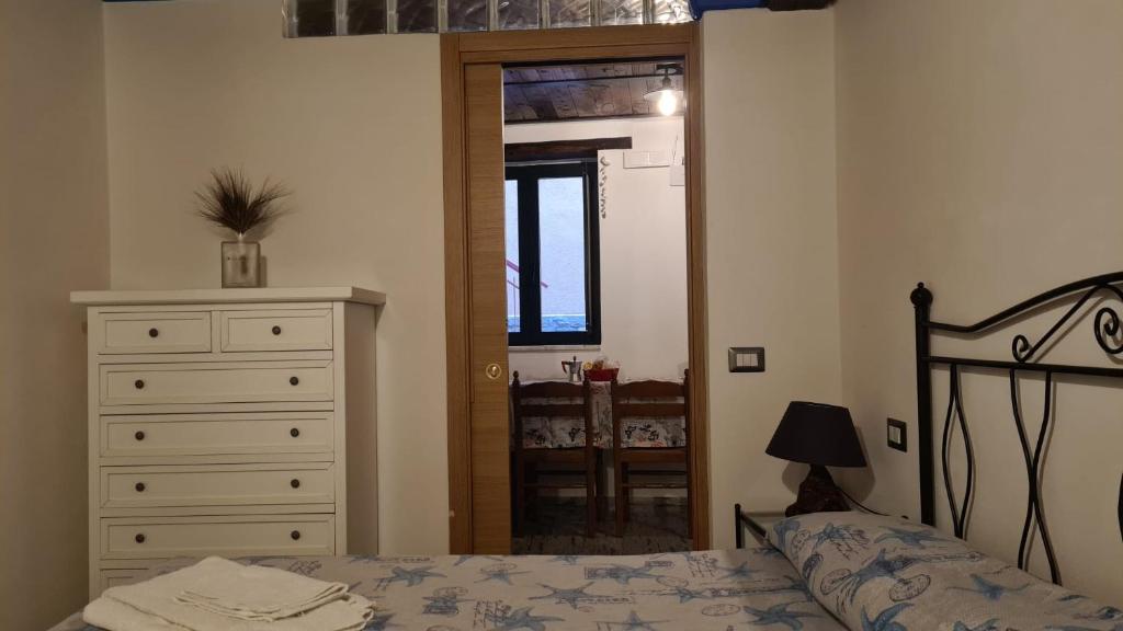 Appartamento Severino - Rariche House في كاميروتا: غرفة نوم بسرير وخزانة ونافذة