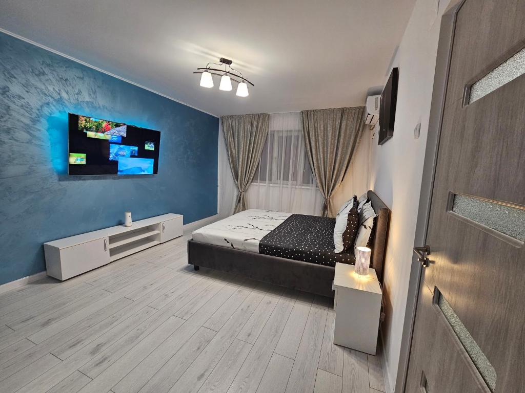 ein Schlafzimmer mit einem Bett und einem TV an der Wand in der Unterkunft Blue Star STUDIO in Craiova