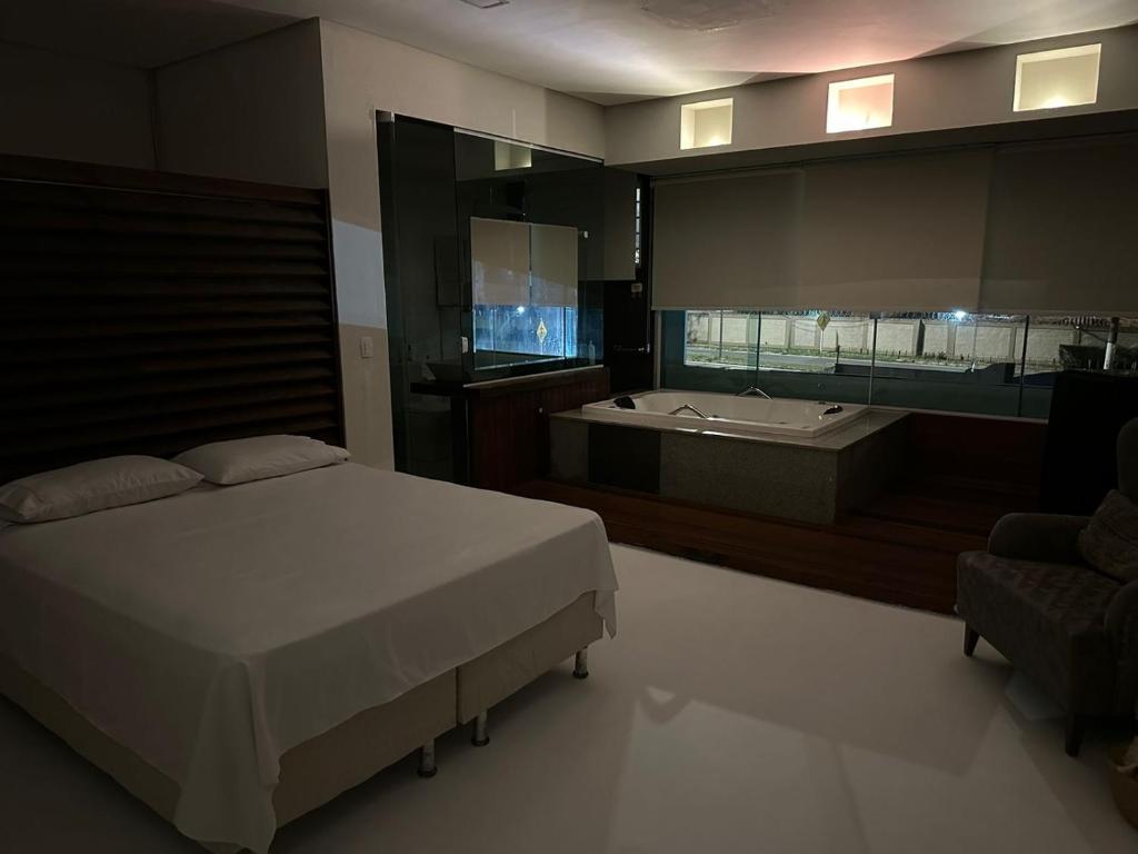 1 dormitorio con cama y bañera en Guarapari Casa de Praia, en Guarapari