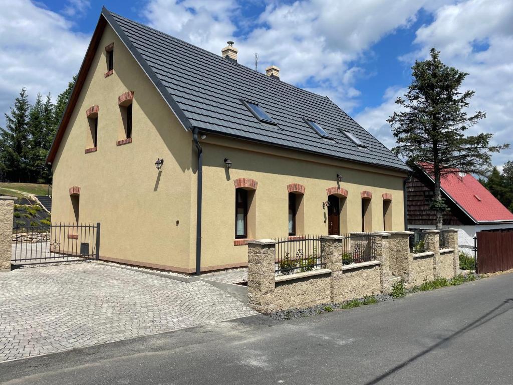 a large building with a black roof on a street at Chalupa Madla in Kalek