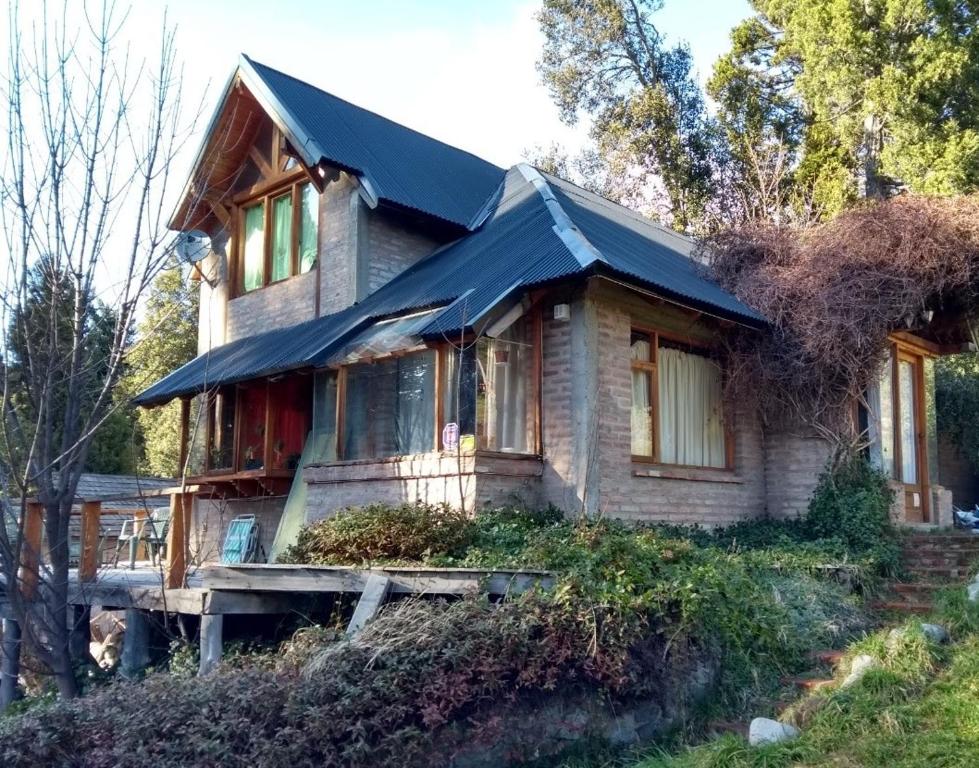 une petite maison avec un toit noir sur un porche dans l'établissement Casa amplia y luminosa, à San Carlos de Bariloche