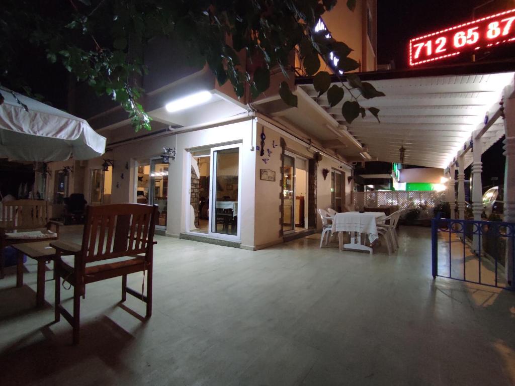 a restaurant with a table and chairs and a sign at AYHAN OTEL in Cesme