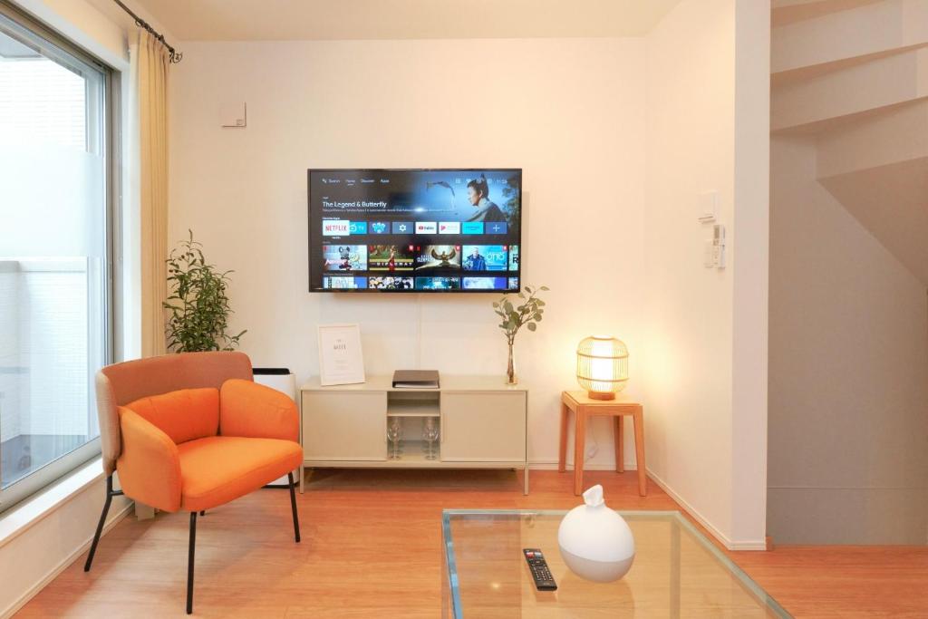 a living room with a chair and a tv on the wall at Seirai Vacation Rental Hatsudai - Vacation STAY 15951v in Tokyo