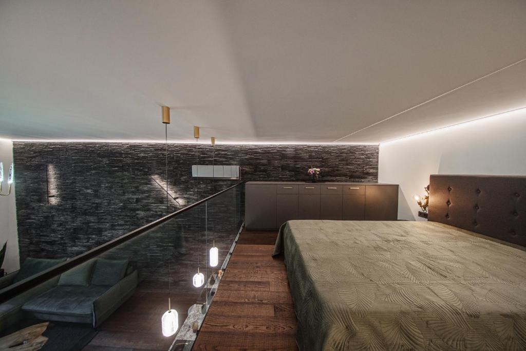 a bedroom with a bed and a brick wall at Sea Forest loft in Klaipėda
