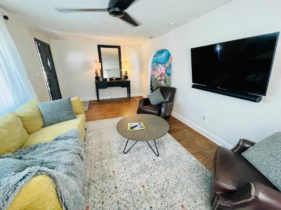 a living room with a couch and a flat screen tv at Luxury - Pet Friendly, Farmhouse Bungalow DT Tampa in Tampa
