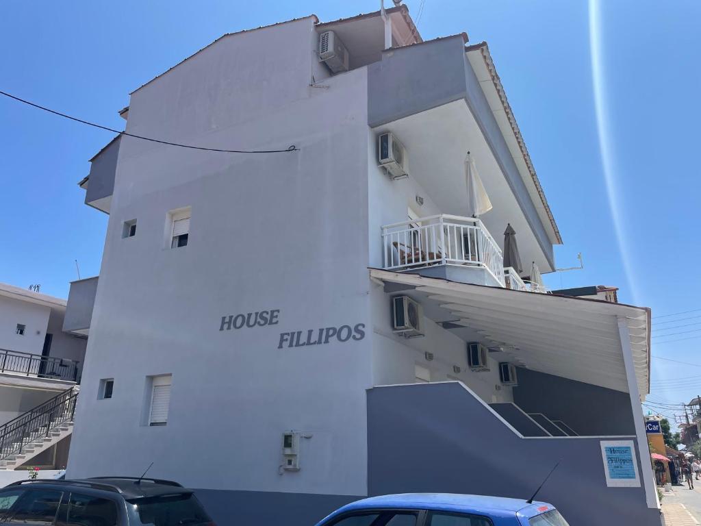 a white building with cars parked in front of it at House Filippos in Sarti