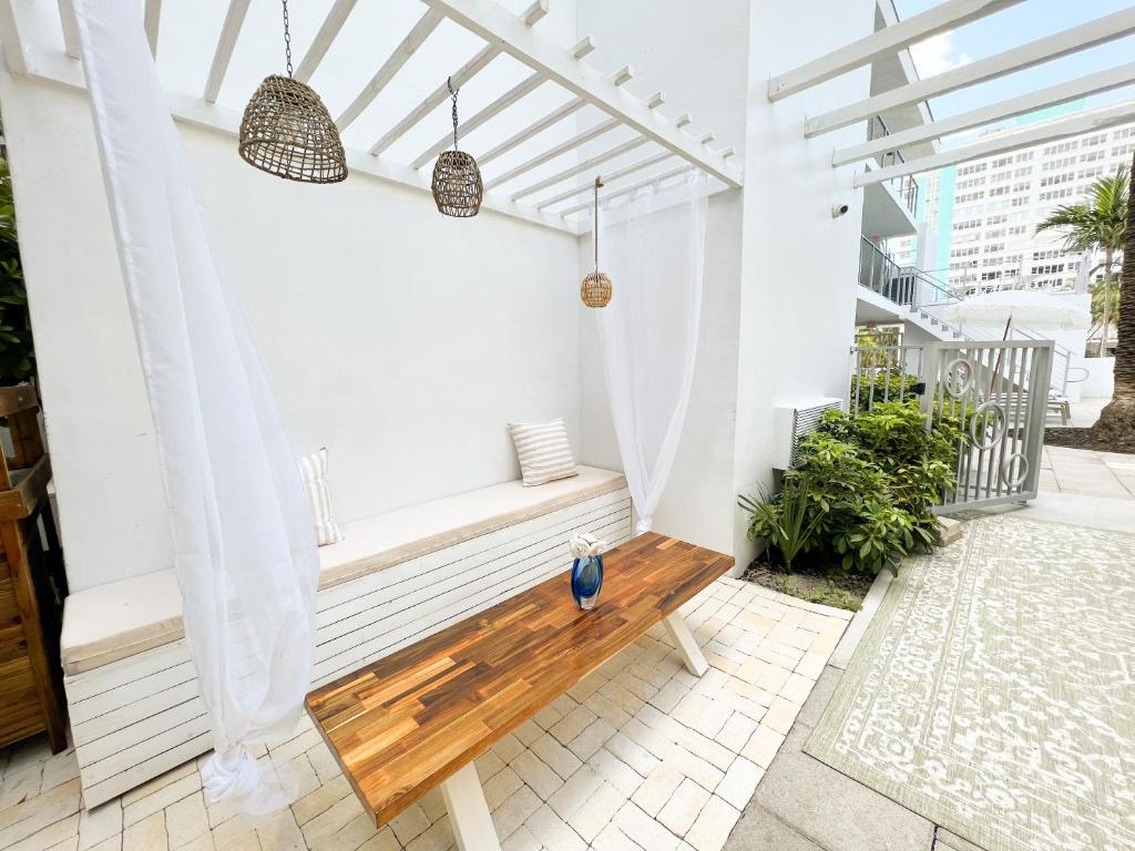 une terrasse couverte avec un banc en bois sur un balcon dans l'établissement Aqua Hotel, à Fort Lauderdale