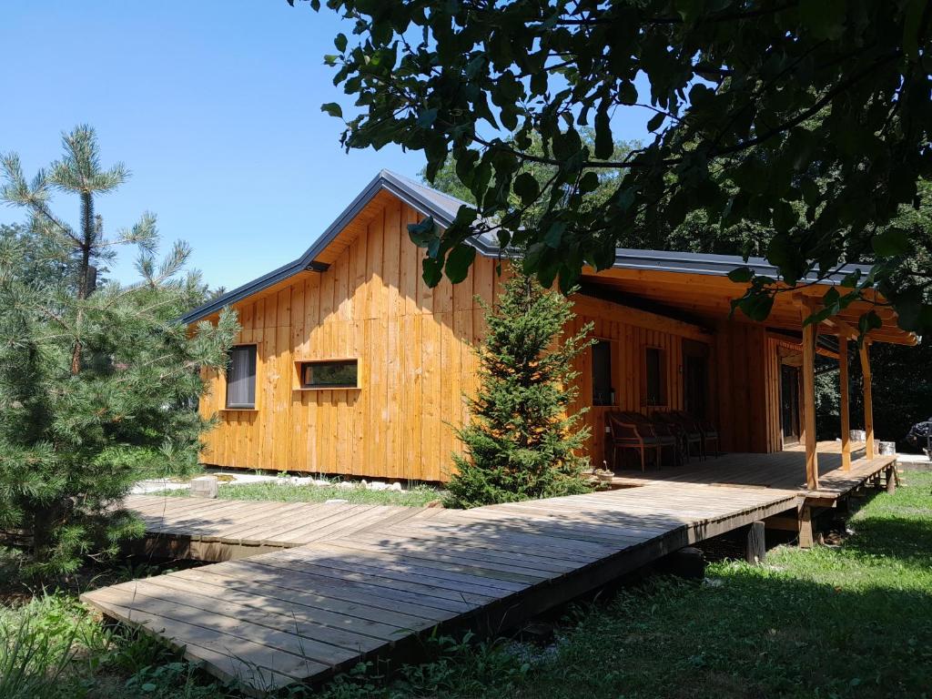 a log cabin with a wooden walkway in front of it at Nica Wood in Sremska Kamenica