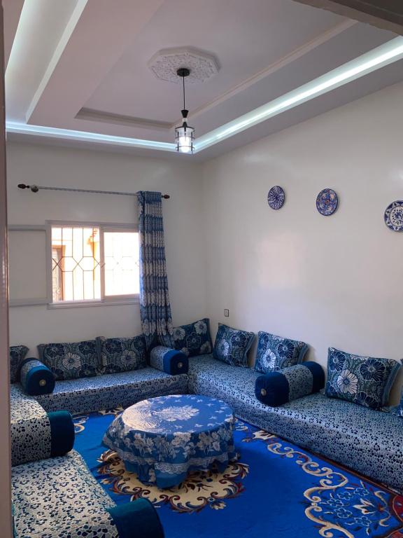 - un salon avec des canapés bleus et une table dans l'établissement Panorama guest house, à Sidi Ifni