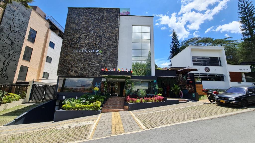 a building with flowers in front of it at Greenview Medellin By St Hoteles in Medellín