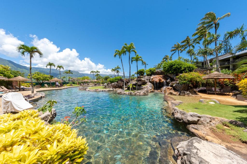 een zwembad in een resort met palmbomen bij Hanalei Bay Resort in Princeville