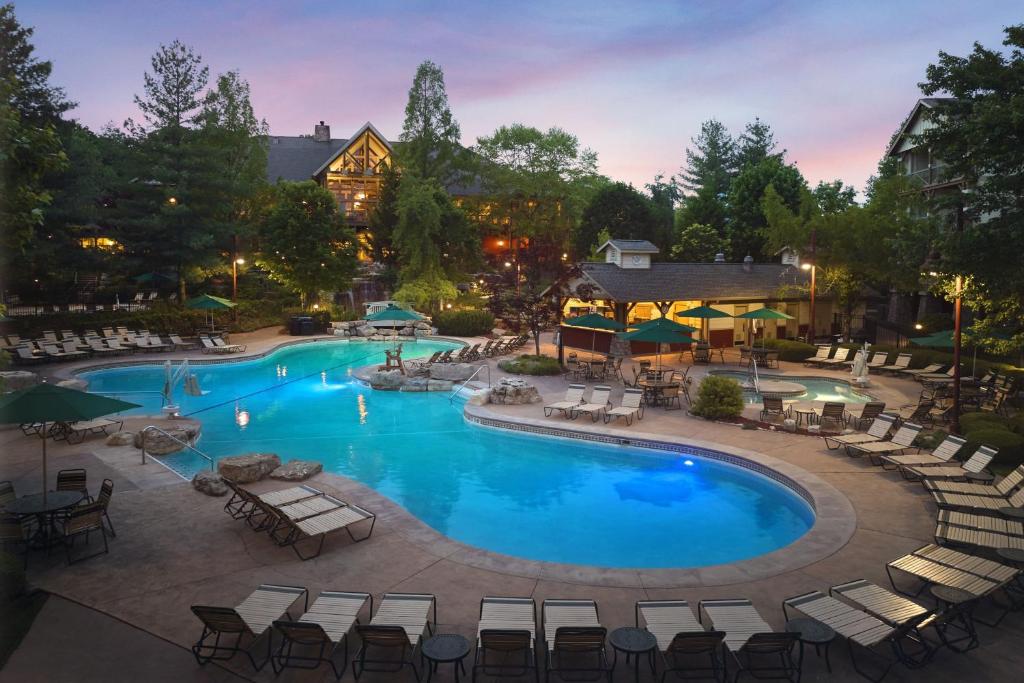 an outdoor pool with chairs and tables and a resort at Marriott's Willow Ridge Lodge in Branson