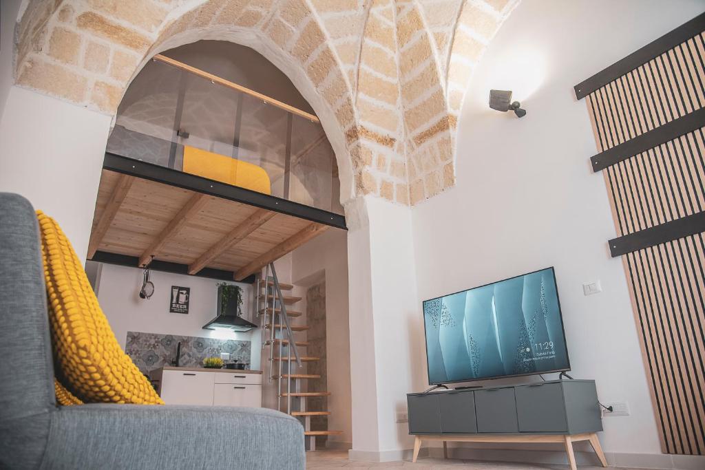 a living room with a couch and a tv at Asmara exclusive "Loft industrial" in Brindisi