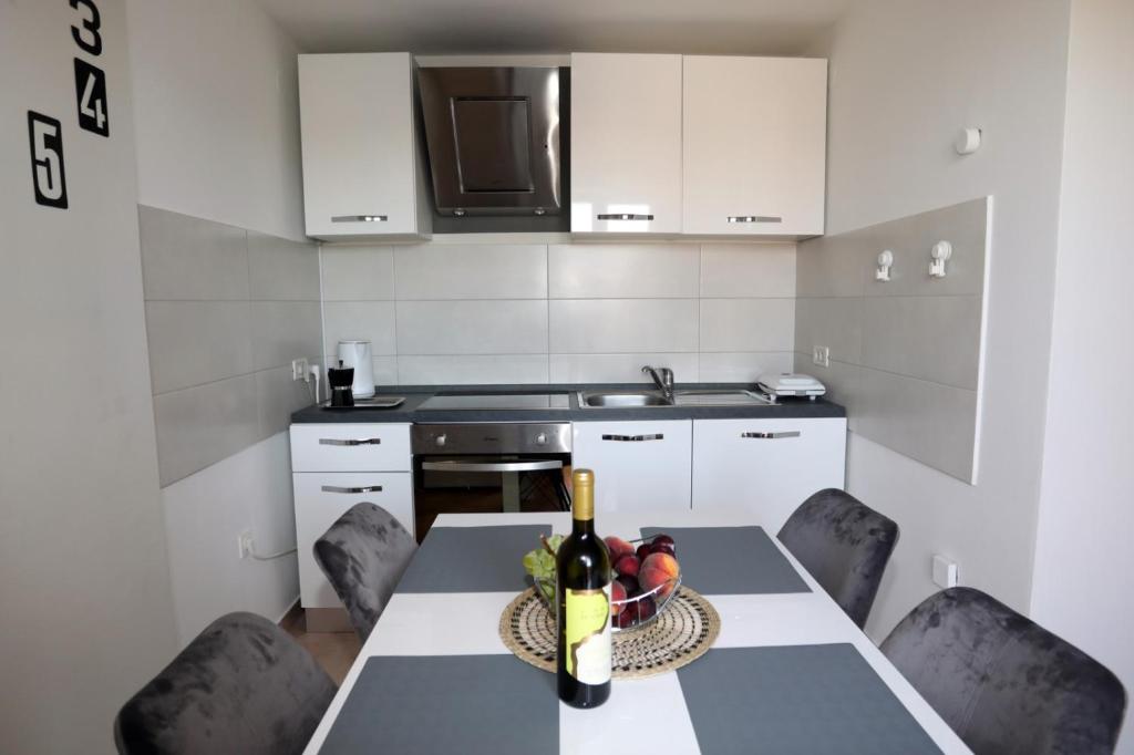 a kitchen with a table with a bowl of fruit on it at Apartman Cinkopan Premantura 1 in Premantura