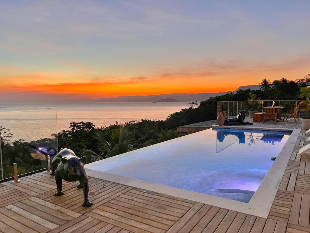 a person is standing next to a swimming pool at Blow Show Casa III Guest House in Ilhabela