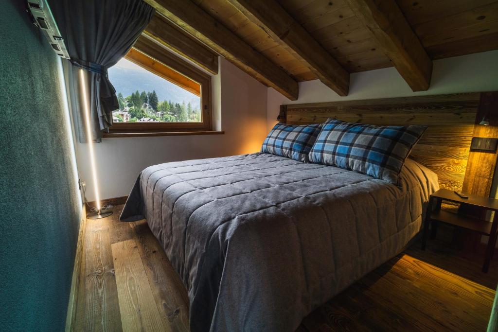 a bedroom with a large bed with a window at Suites Courmayeur - Mont Blanc in Courmayeur